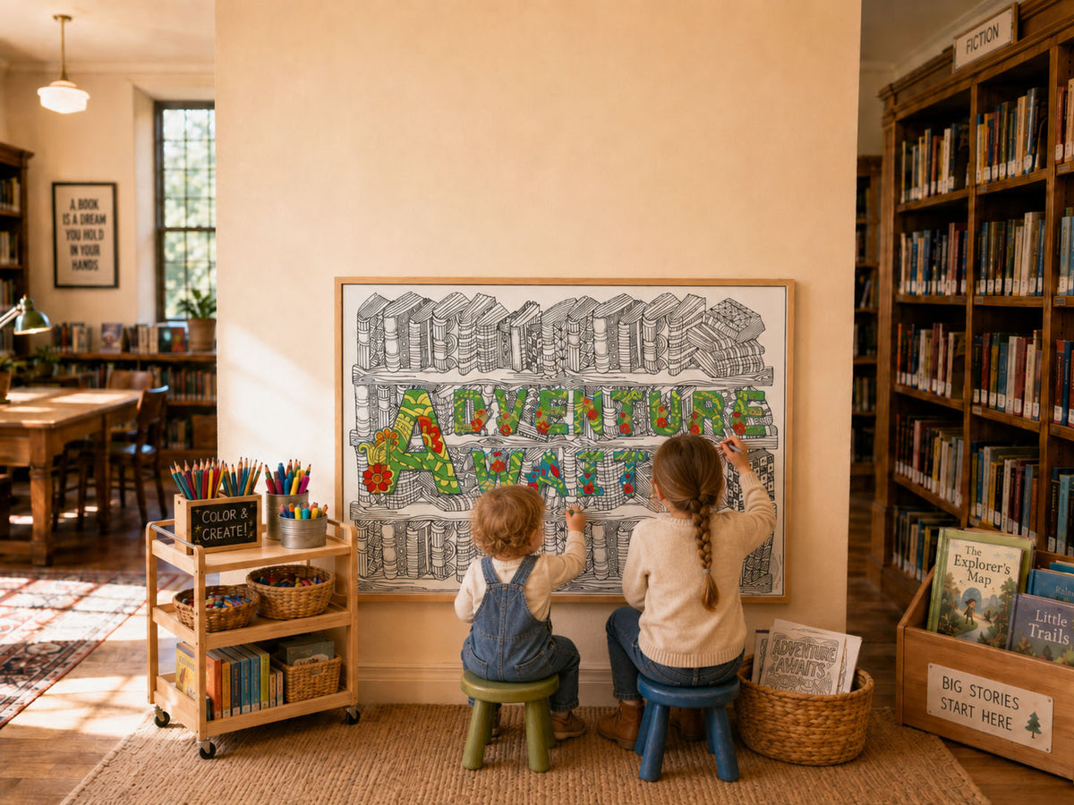 Two children sitting on stools coloring a giant coloring poster in a public library, framed on the wall between bookshelves